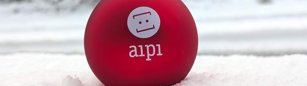 Weihnachtsbaumkugel in rot im Schnee vor dem Büro von aipi Weihnachtsbaumkugel in rot im Schnee vor dem Büro von aipi